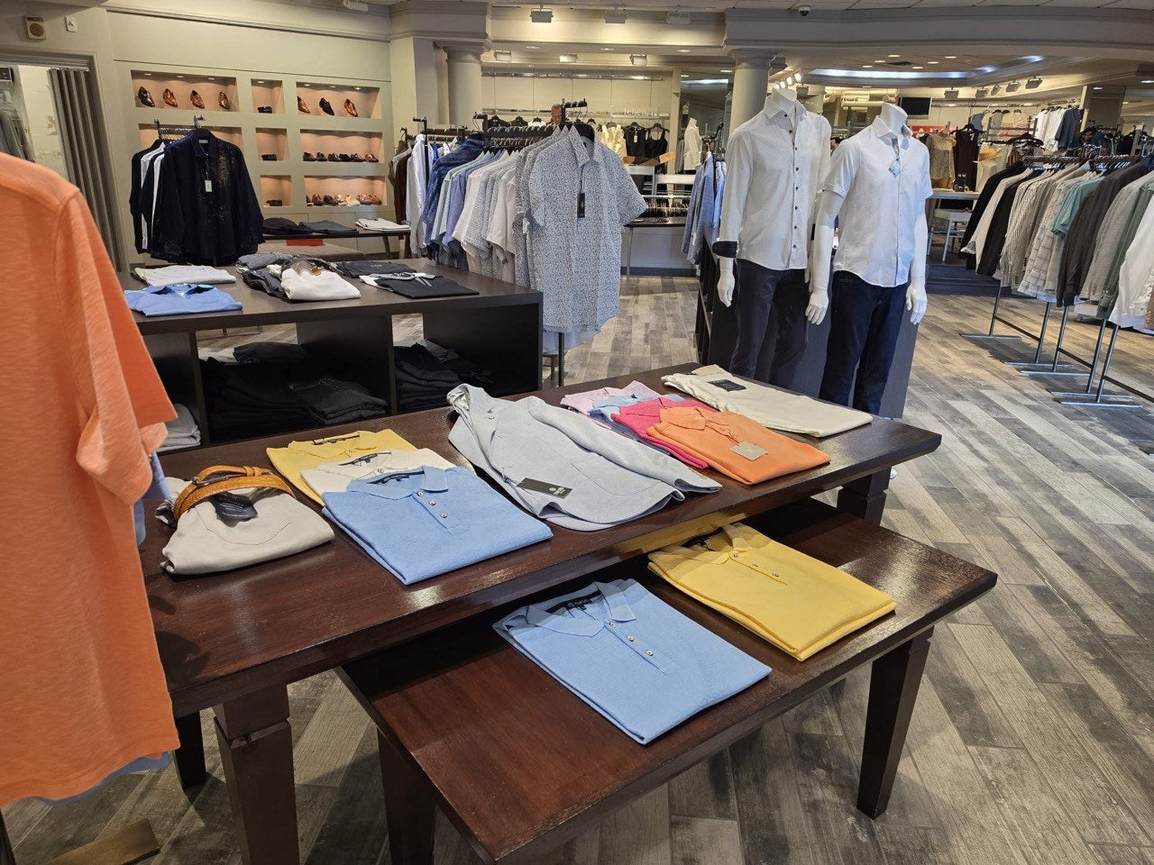 Colorful folded polos and shirts displayed throughout the store