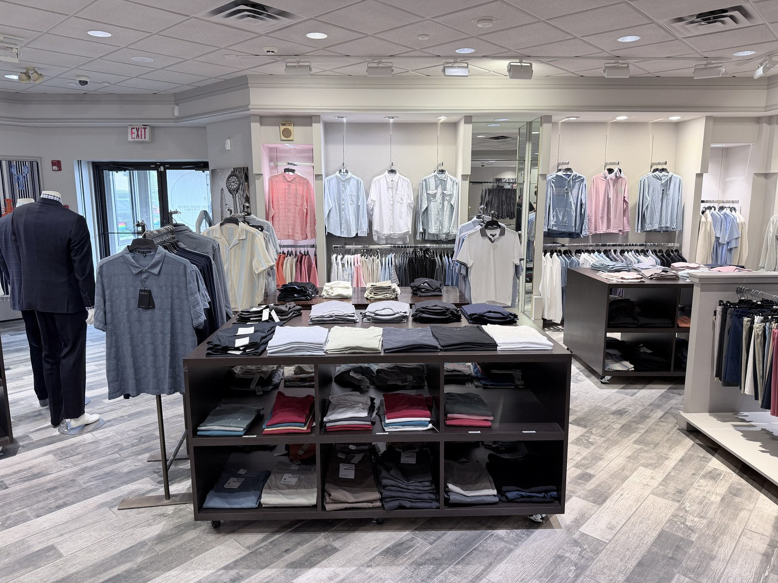 Menswear displays with shirts, polos, and tailored clothing at Lee Newman